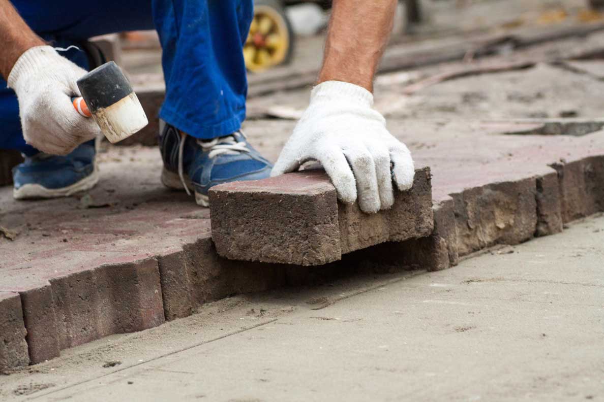 Professional Workers Laying Paving Slabs By Mosaic Close Up In Blue Overalls